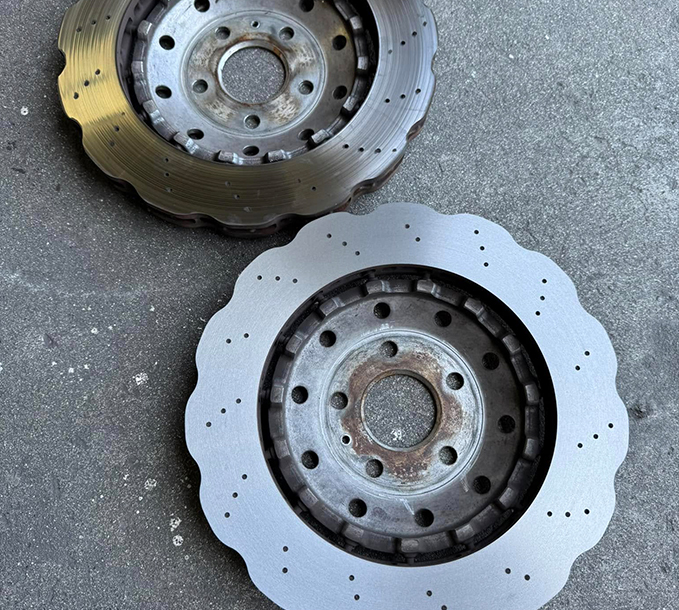Two drilled and slotted brake discs laid out for inspection