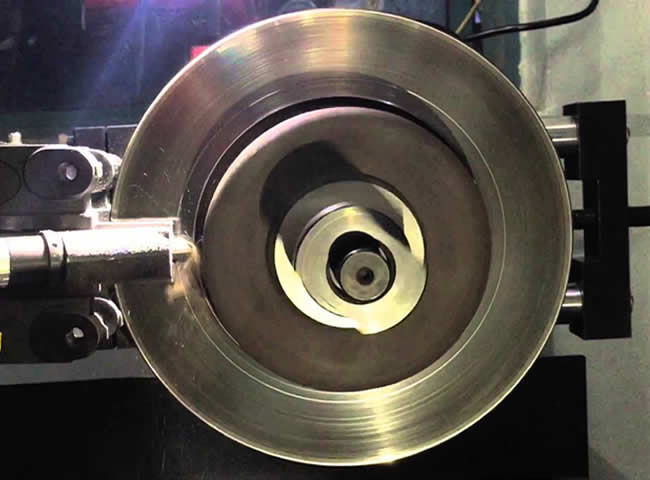 Brake rotor secured on a bench lathe for resurfacing