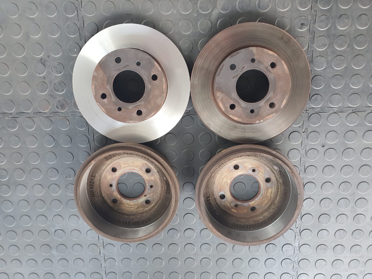 Four brake discs showing contrasting surface conditions