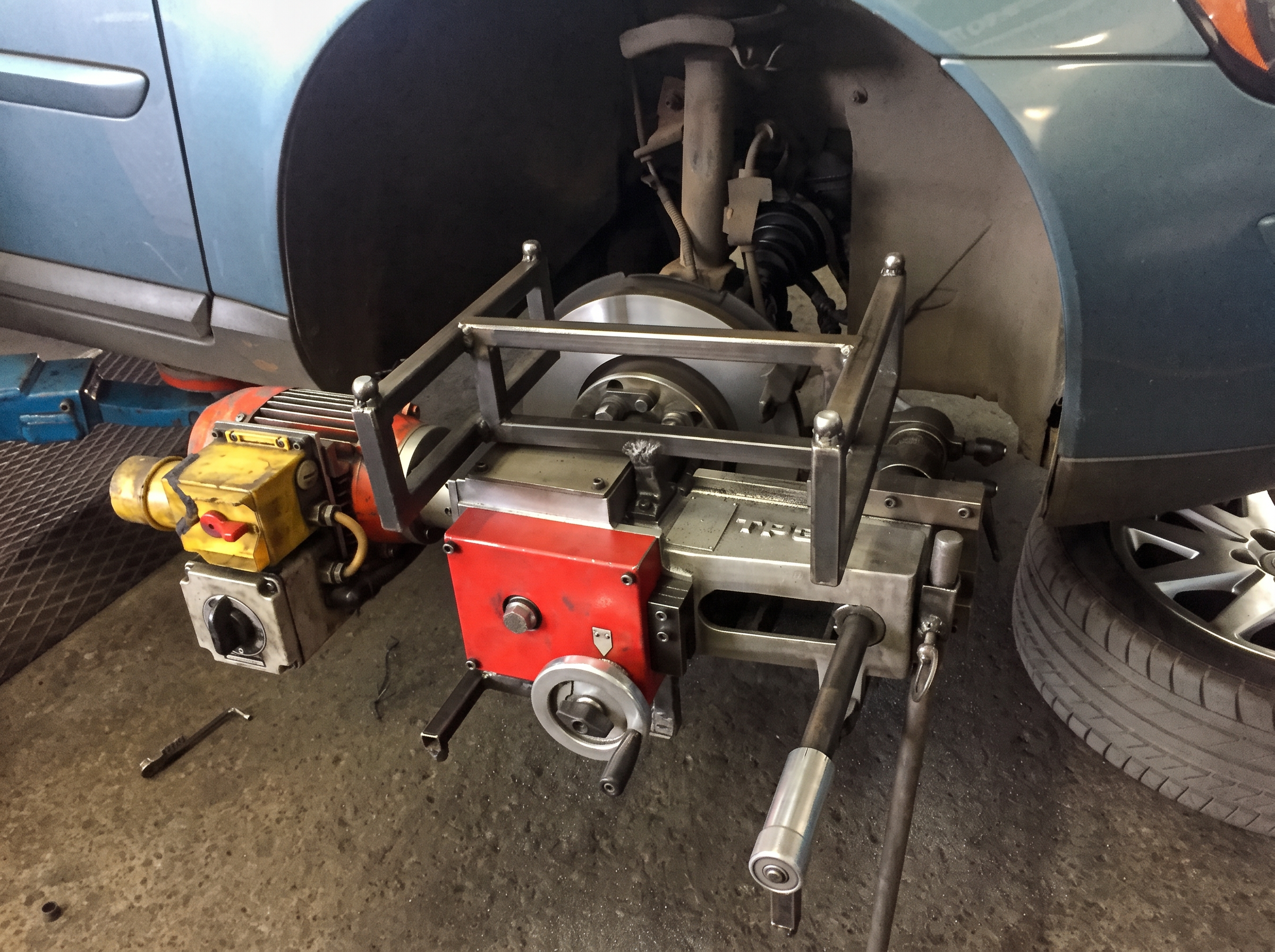On-car brake disc skimming equipment attached to a vehicle